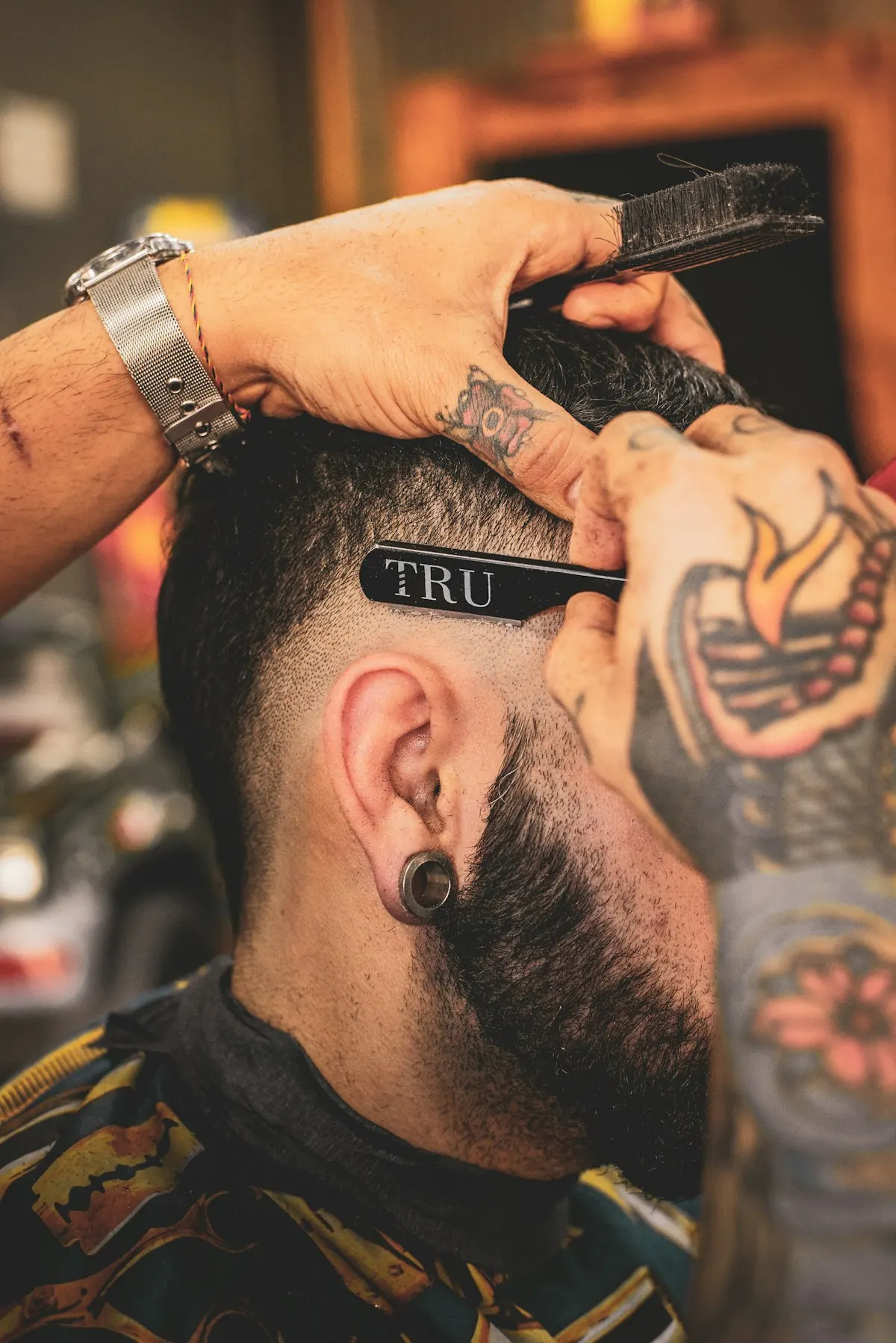 Barbeiro fazendo o acabamento do corte na navalha