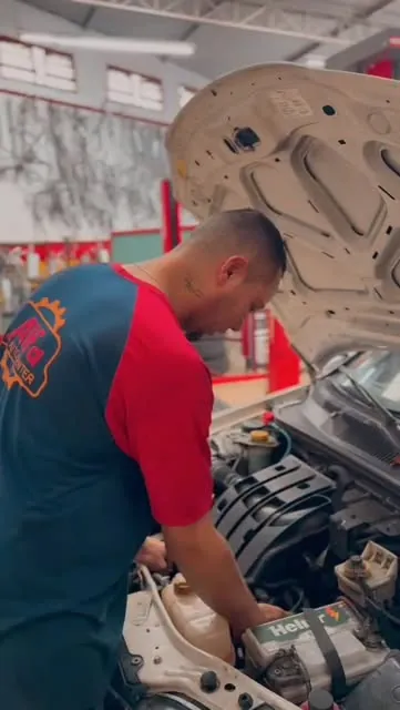 Mecânico da Alfa trabalhando no motor de um carro